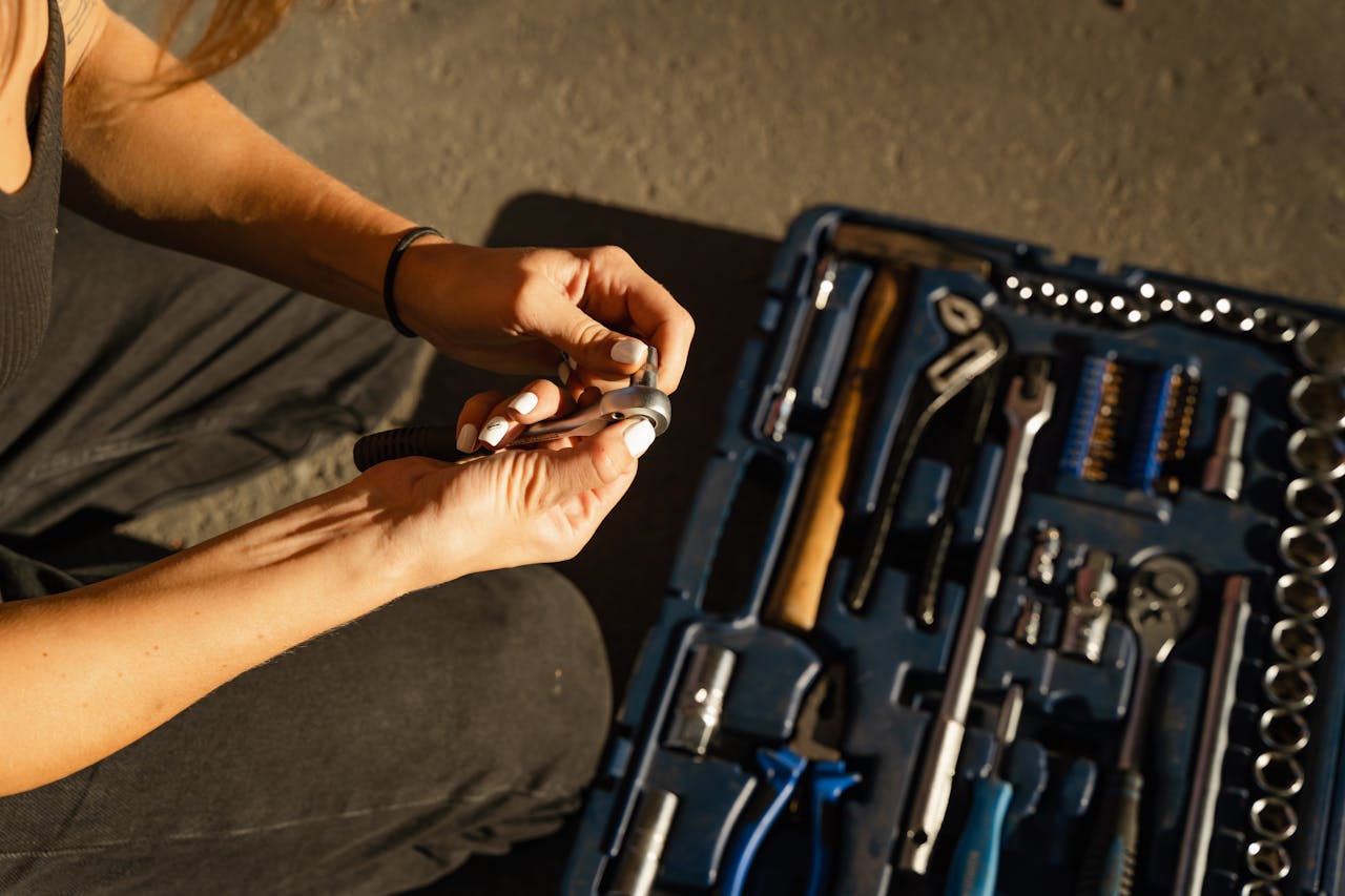 hero-gallery-01 Close-up of hands using tools from a toolset in a well-lit workshop setting.